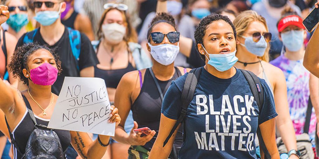 Dozens marching with signs and face-masks on during a Black Lives Matter protest.